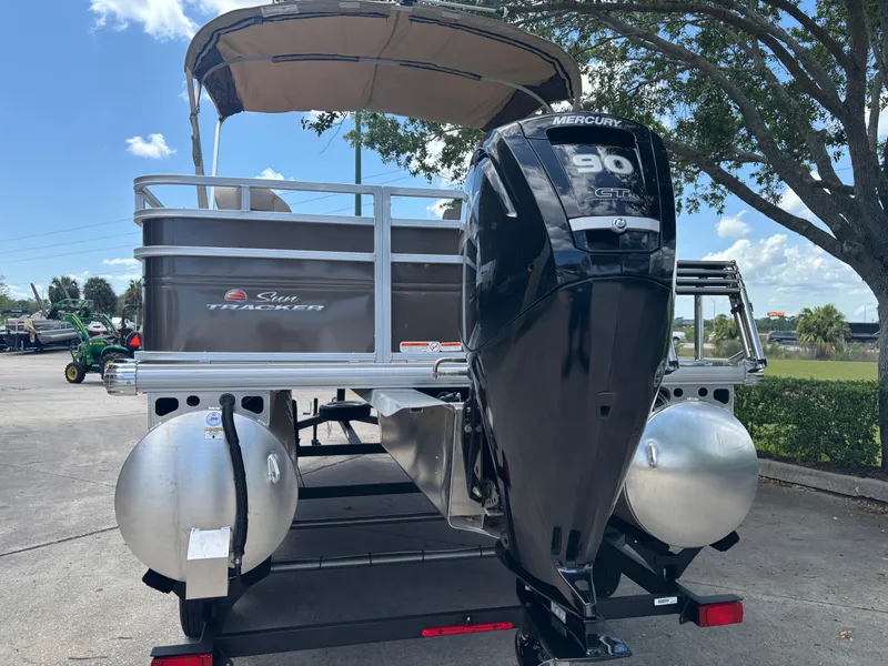 Slide: The Image of 2025 Sun Tracker SportFish 20 DLX pontoon boat with Mercury 90 engine, parked outdoors. - 3