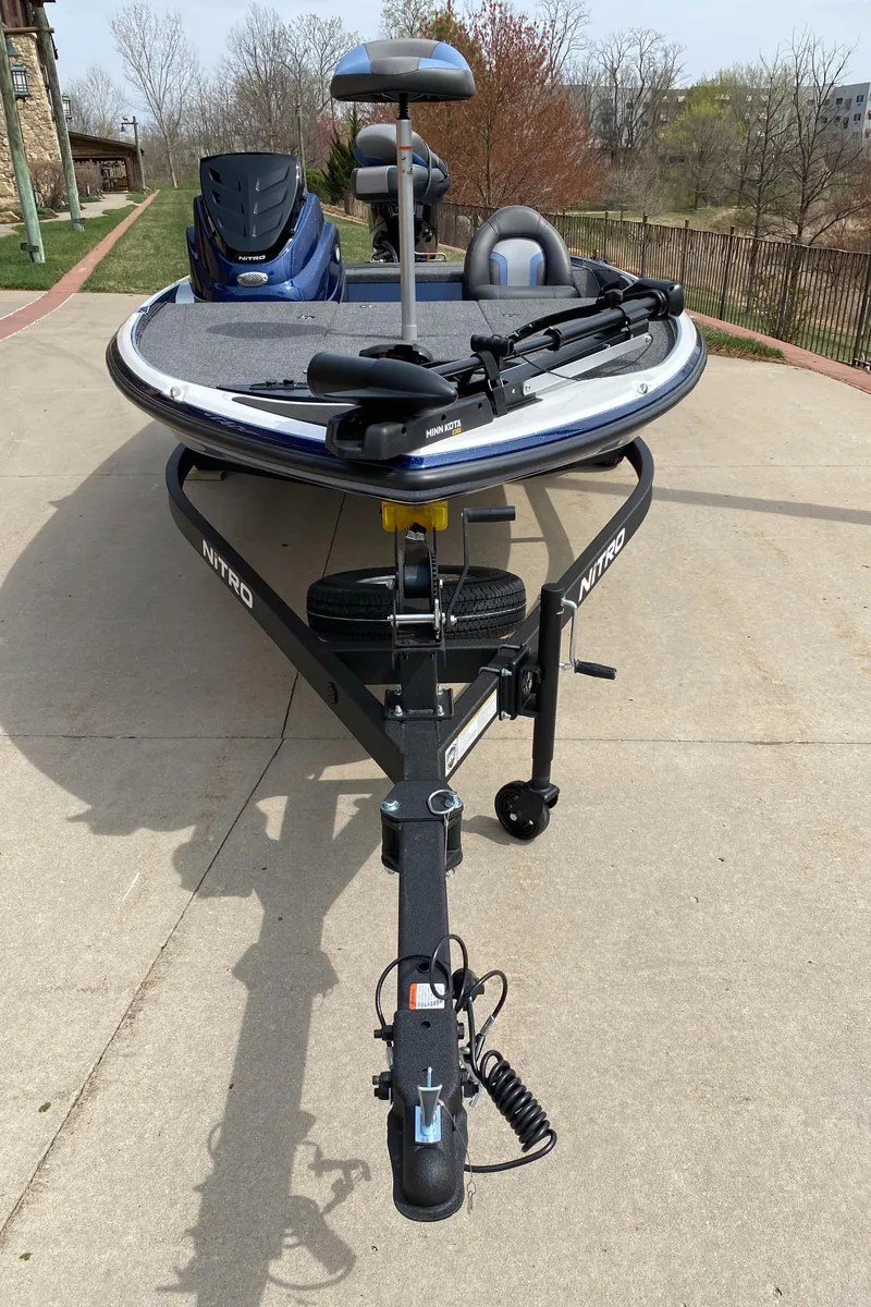 Slide: The Image of 2025 Nitro Z17 boat on trailer, parked on concrete driveway. - 2