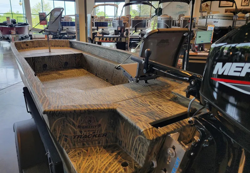 Slide: The Image of 2025 Tracker Grizzly 1650 T Prairie Wings Edition boat with camouflage design in showroom. - 4