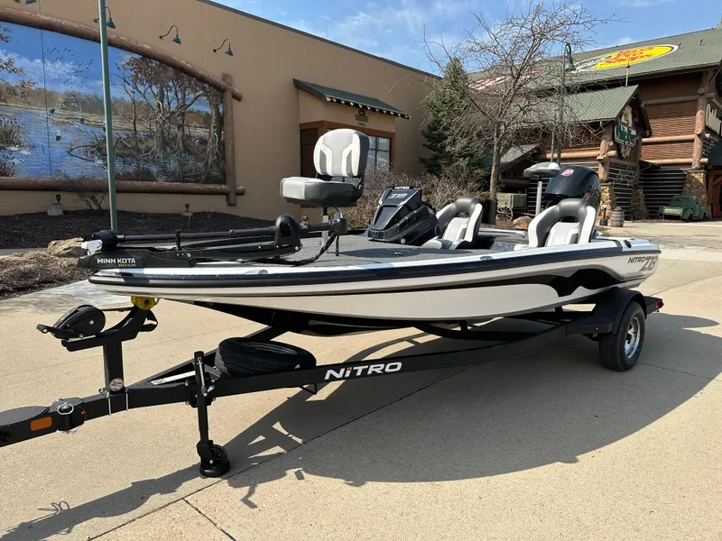 Slide: The Image of 2025 Nitro Z18 fishing boat on trailer, parked outdoors near rustic building. - 1