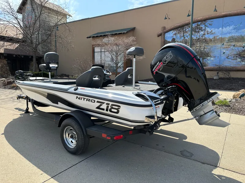 Slide: The Image of 2025 Nitro Z18 boat with motor, parked outdoors on a sunny day. - 2