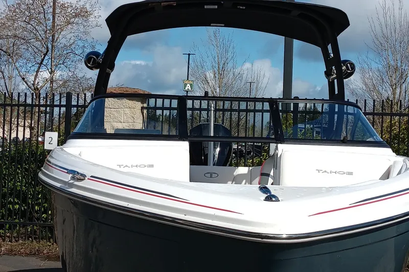 Slide: The Image of 2024 Tahoe 210 S boat with sleek design, docked outdoors. - 2