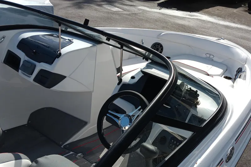 Slide: The Image of 2024 Tahoe 210 S boat interior with steering wheel and seating area. - 3