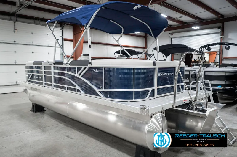Slide: The Image of 2025 Bennington 22 SSR pontoon boat with blue canopy in showroom. - 10