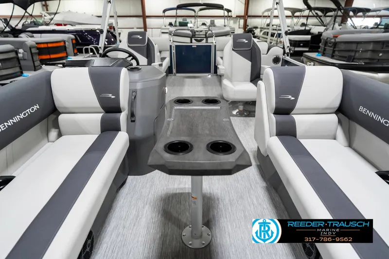 Slide: The Image of 2025 Bennington 22 SSR boat interior with gray seating and table, showcased at Reeder-Trausch Marine. - 16