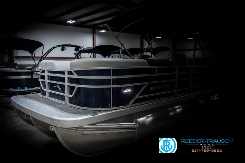 Slide: The Image of 2025 Bennington 22 SSR pontoon boat in a dimly lit showroom. - 4