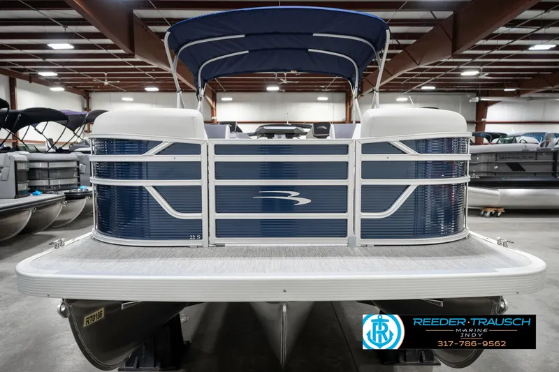 Slide: The Image of 2025 Bennington 22 SSR pontoon boat in showroom, front view with blue and white design. - 5