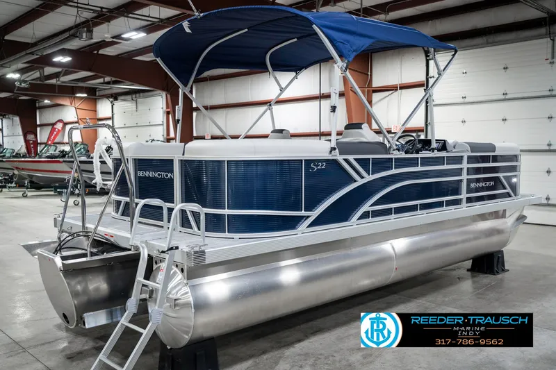 Slide: The Image of 2025 Bennington 22 SSR pontoon boat with blue canopy in a showroom. - 8