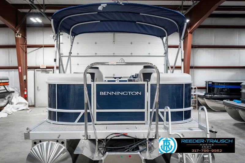 Slide: The Image of 2025 Bennington 22 SSR pontoon boat in a showroom with blue canopy. - 9