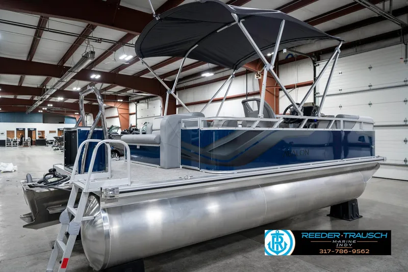 Slide: The Image of 2025 Avalon 1785 Venture CRB pontoon boat in showroom, featuring sleek design and canopy. - 7