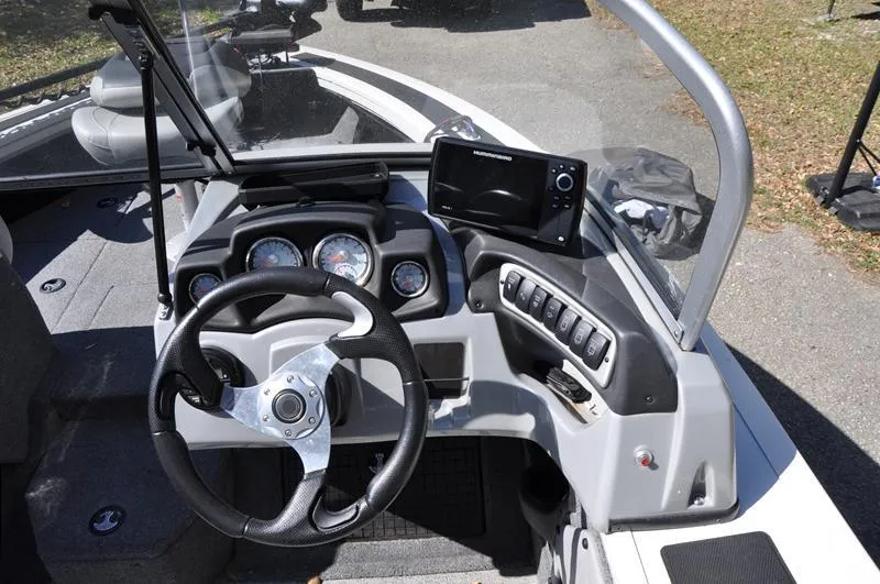 Slide: The Image of 2019 Tracker Targa V-19 Combo Tournament Edition boat dashboard with steering wheel and controls. - 10