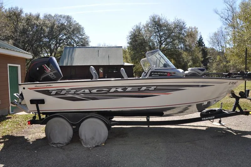 Slide: The Image of 2019 Tracker Targa V-19 Combo Tournament Edition boat on trailer, parked outdoors. - 4