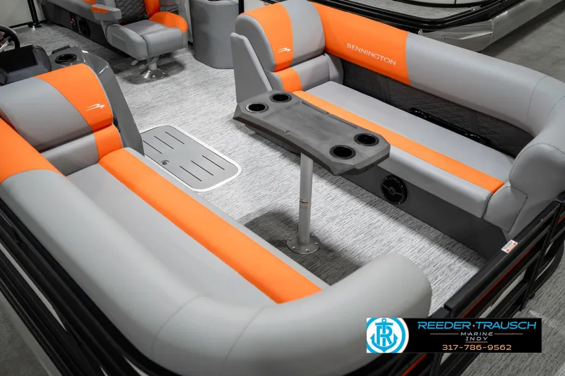 Slide: The Image of 2025 Bennington 21 SSR boat interior with gray and orange seating, featuring a central table. - 12