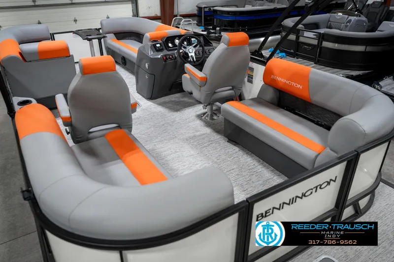 Slide: The Image of 2025 Bennington 21 SSR pontoon boat with gray and orange seating in showroom. - 13