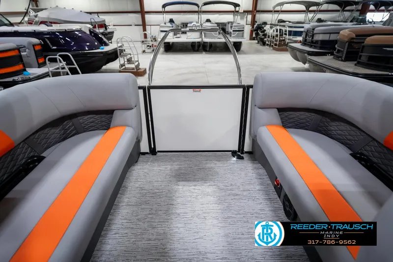 Slide: The Image of 2025 Bennington 21 SSR pontoon boat interior with orange accents in a showroom. - 17