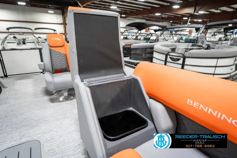 Slide: The Image of 2025 Bennington 21 SSR boat interior with open storage compartment, orange seating, showroom display. - 23