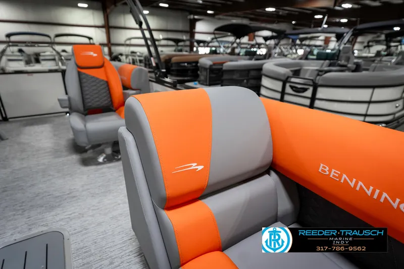 Slide: The Image of 2025 Bennington 21 SSR boat interior with orange and gray seating in showroom. - 24