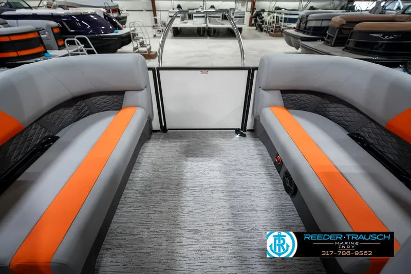 Slide: The Image of 2025 Bennington 21 SSR pontoon boat interior with gray and orange seating in showroom. - 25