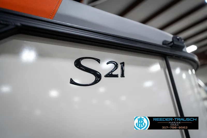 Slide: The Image of 2025 Bennington 21 SSR boat with "S21" emblem, indoor display. - 48