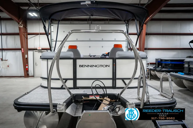 Slide: The Image of 2025 Bennington 21 SSR pontoon boat in a warehouse, rear view with logo visible. - 8