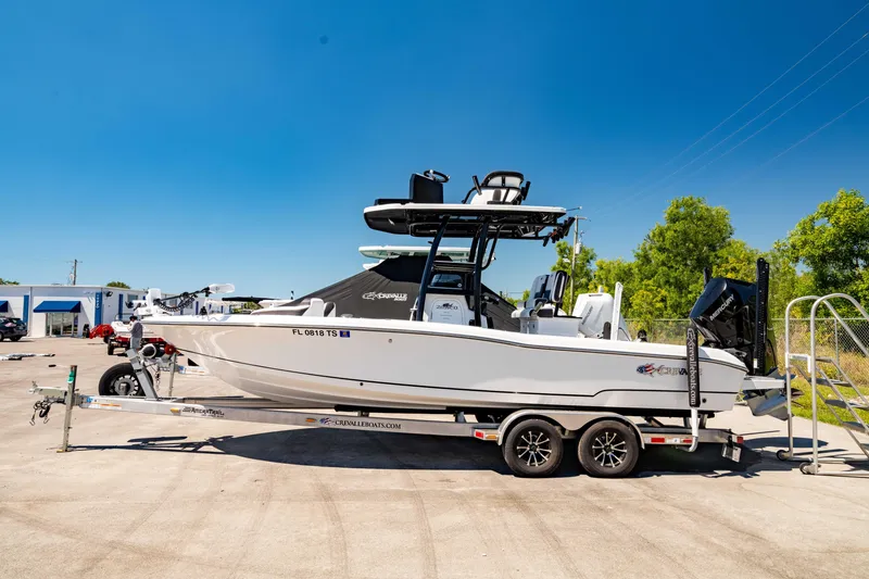 Slide: The Image of 2024 Crevalle 26 HCO boat on trailer, parked outdoors under clear blue sky. - 0