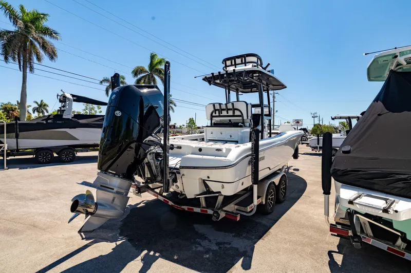Slide: The Image of 2024 Crevalle 26 HCO boat on trailer, parked outdoors under clear blue sky. - 13