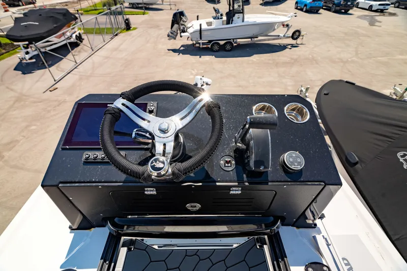Slide: The Image of 2024 Crevalle 26 HCO boat dashboard with steering wheel and controls. - 16