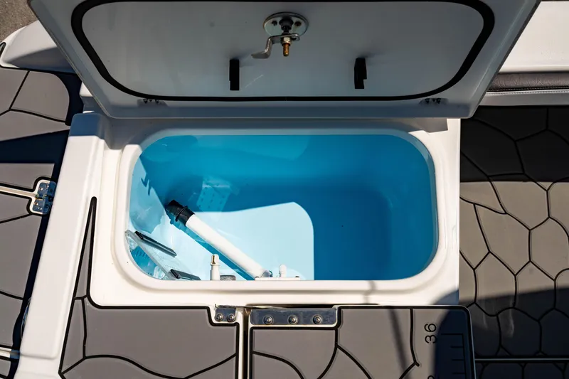 Slide: The Image of Open storage compartment on 2024 Crevalle 26 HCO boat, featuring a blue interior. - 18