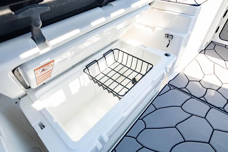 Slide: The Image of 2024 Crevalle 26 HCO boat storage compartment with wire basket and patterned flooring. - 21