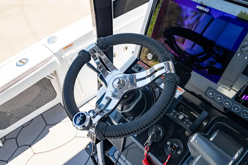Slide: The Image of 2024 Crevalle 26 HCO boat helm with modern steering wheel and navigation display. - 32