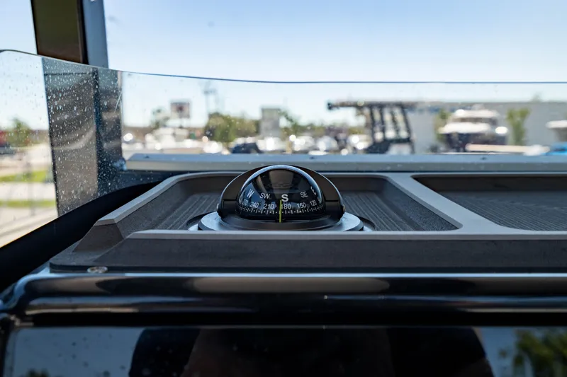 Slide: The Image of 2024 Crevalle 26 HCO boat compass on dashboard, close-up view. - 39