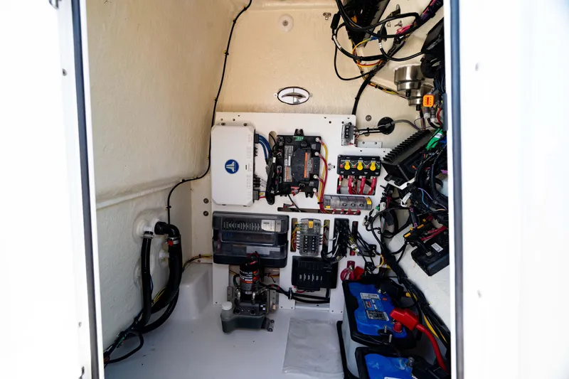 Slide: The Image of 2024 Crevalle 26 HCO boat electrical compartment with wiring and battery setup. - 41