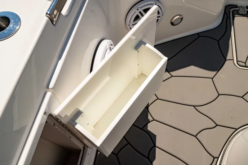 Slide: The Image of Open storage compartment on 2024 Crevalle 26 HCO boat with hexagonal floor design. - 44