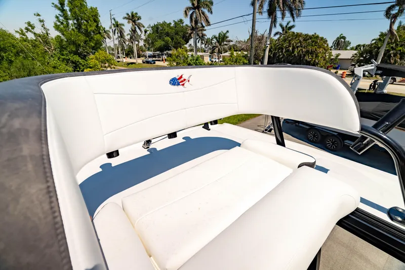Slide: The Image of 2024 Crevalle 26 HCO boat seat with American flag logo, surrounded by palm trees. - 8