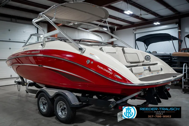 Slide: The Image of 2014 Yamaha Boats 242 Limited S in showroom, red and white, on trailer. - 10