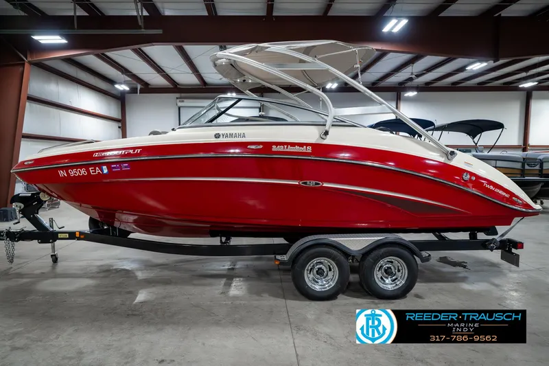 Slide: The Image of 2014 Yamaha Boats 242 Limited S in red, displayed indoors on a trailer. - 11