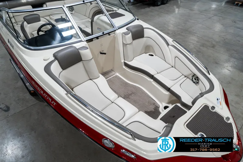 Slide: The Image of 2014 Yamaha Boats 242 Limited S interior with white and gray seating, showcased in a showroom. - 13