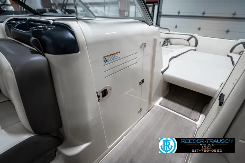 Slide: The Image of 2014 Yamaha Boats 242 Limited S interior with seating and storage, showcased in a showroom. - 23