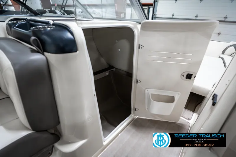 Slide: The Image of 2014 Yamaha Boats 242 Limited S interior storage compartment with open door. - 24