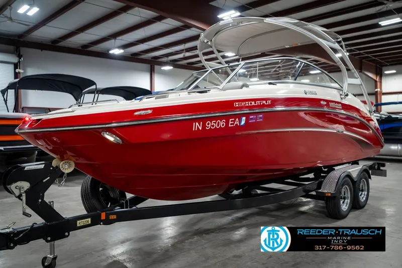 Slide: The Image of 2014 Yamaha Boats 242 Limited S in showroom, red exterior, on trailer. - 3