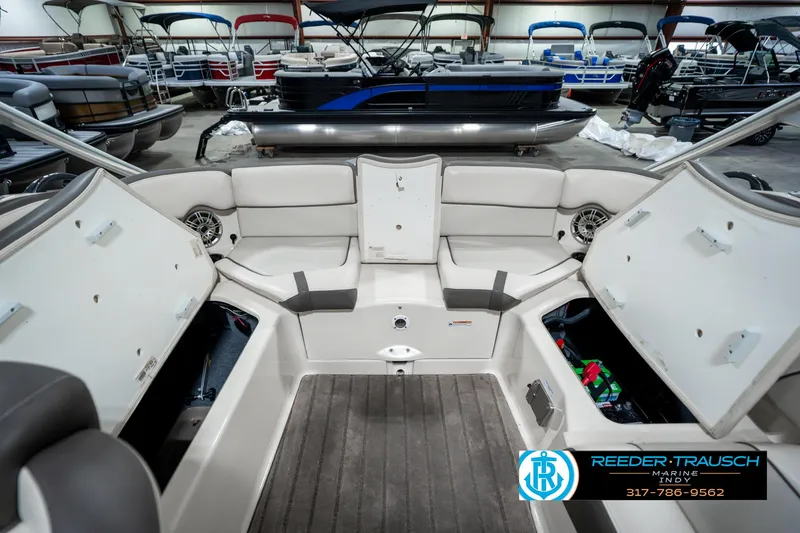 Slide: The Image of 2014 Yamaha Boats 242 Limited S interior with open storage compartments in a showroom. - 30