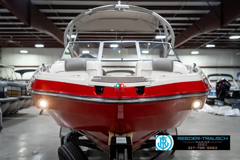 Slide: The Image of 2014 Yamaha Boats 242 Limited S in showroom, red hull, front view, indoor lighting. - 5
