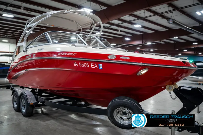 Slide: The Image of 2014 Yamaha Boats 242 Limited S in showroom, red exterior, on trailer. - 6