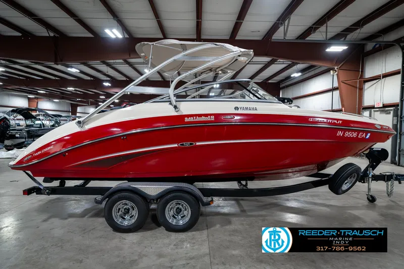 Slide: The Image of 2014 Yamaha Boats 242 Limited S in a showroom, red and white design, on a trailer. - 7