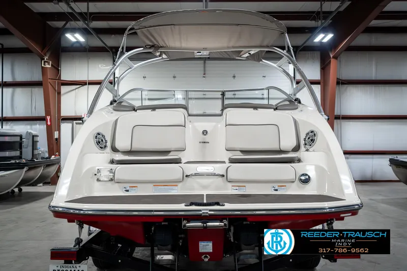 Slide: The Image of 2014 Yamaha Boats 242 Limited S in showroom, rear view with seating and canopy. - 9