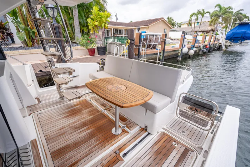 Slide: The Image of 2021 Skamander Monaco yacht deck with wooden table and seating by the water. - 22