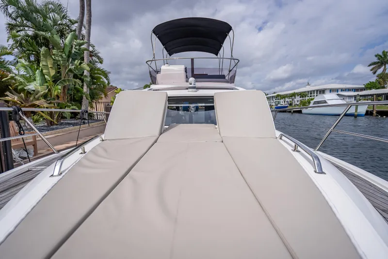 Slide: The Image of Luxury Skamander Monaco 2021 yacht with sunbathing deck, docked by palm trees and waterfront homes. - 25