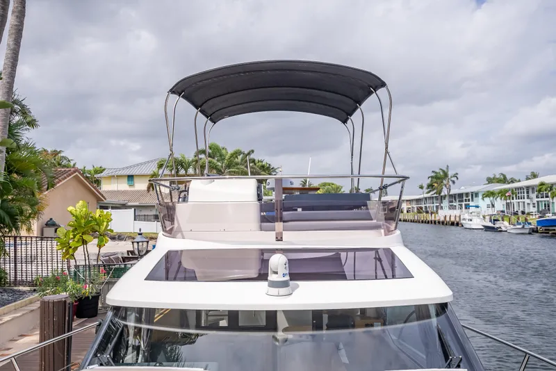 Slide: The Image of 2021 Skamander Monaco yacht with canopy, docked by a canal under cloudy skies. - 26