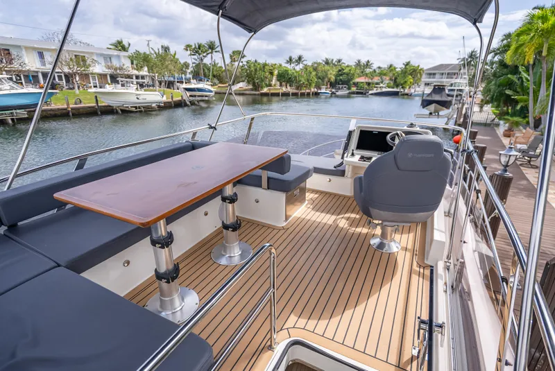 Slide: The Image of Luxurious 2021 Skamander Monaco yacht deck with seating and helm, overlooking a serene waterfront. - 29