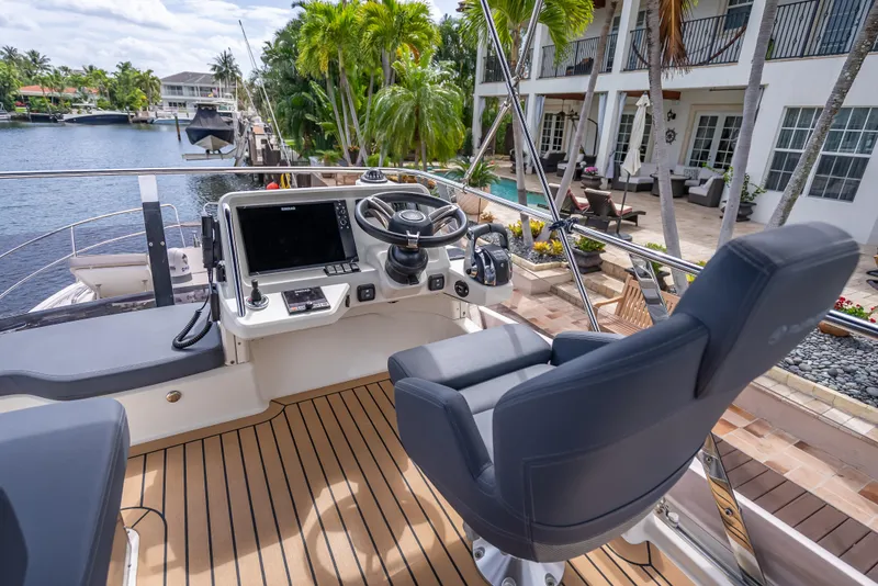 Slide: The Image of Luxury Skamander Monaco 2021 yacht helm with modern controls, docked by waterfront property. - 30